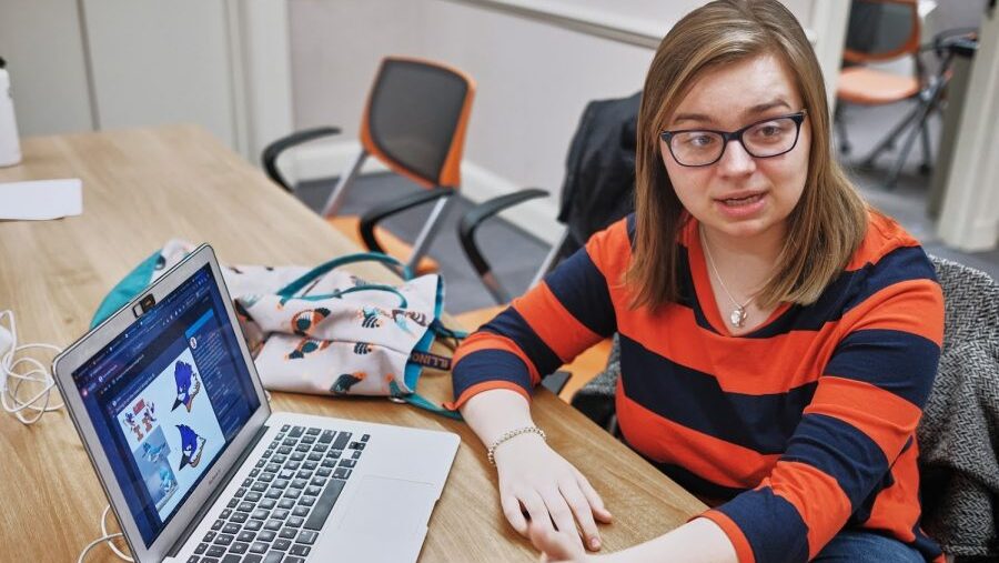 Spencer Hulsey presenting a laptop with graphics of the Belted Kingfisher mascot