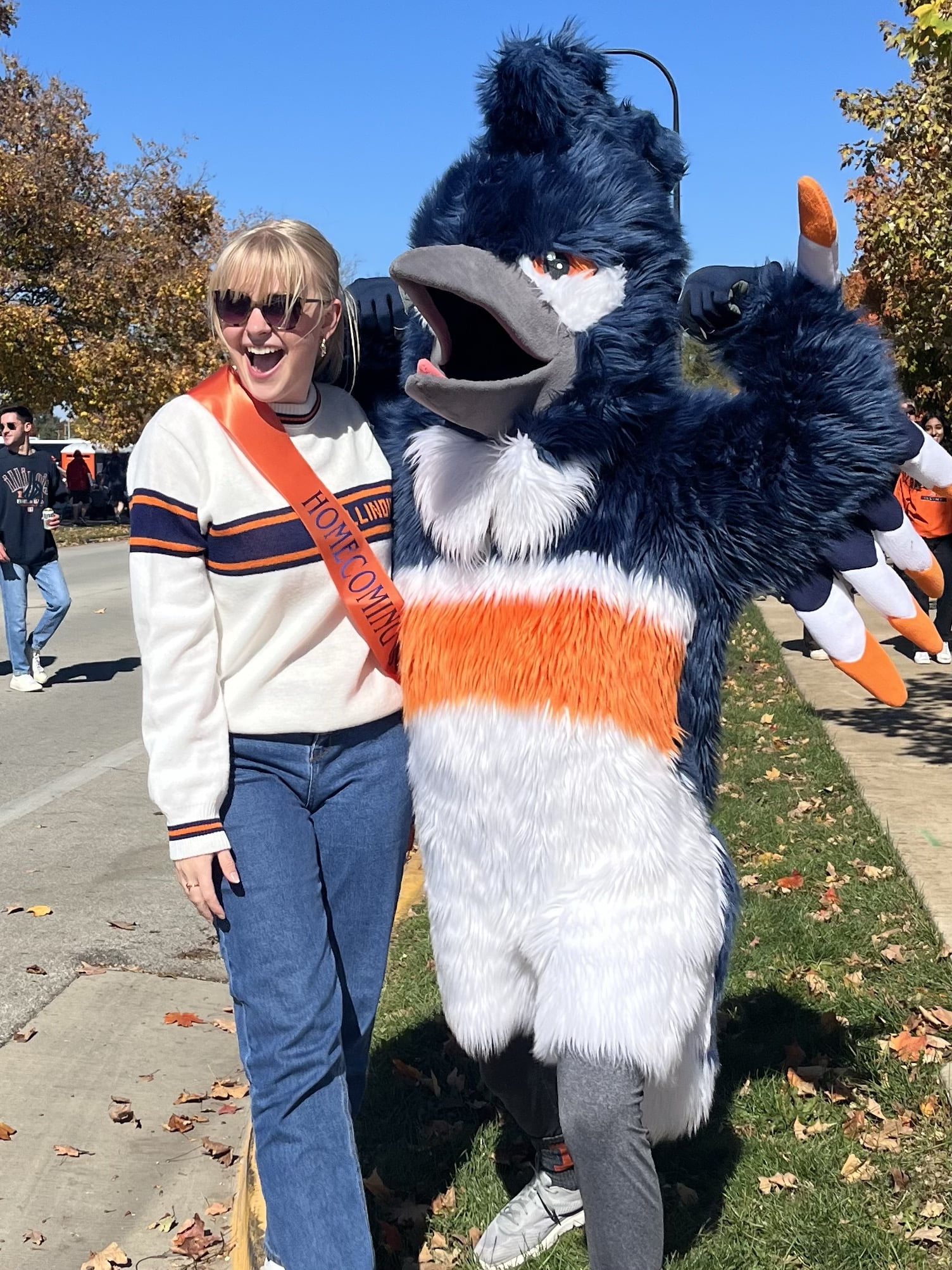 The Belted Kingfisher posing next to a student with a Homecoming Court sash