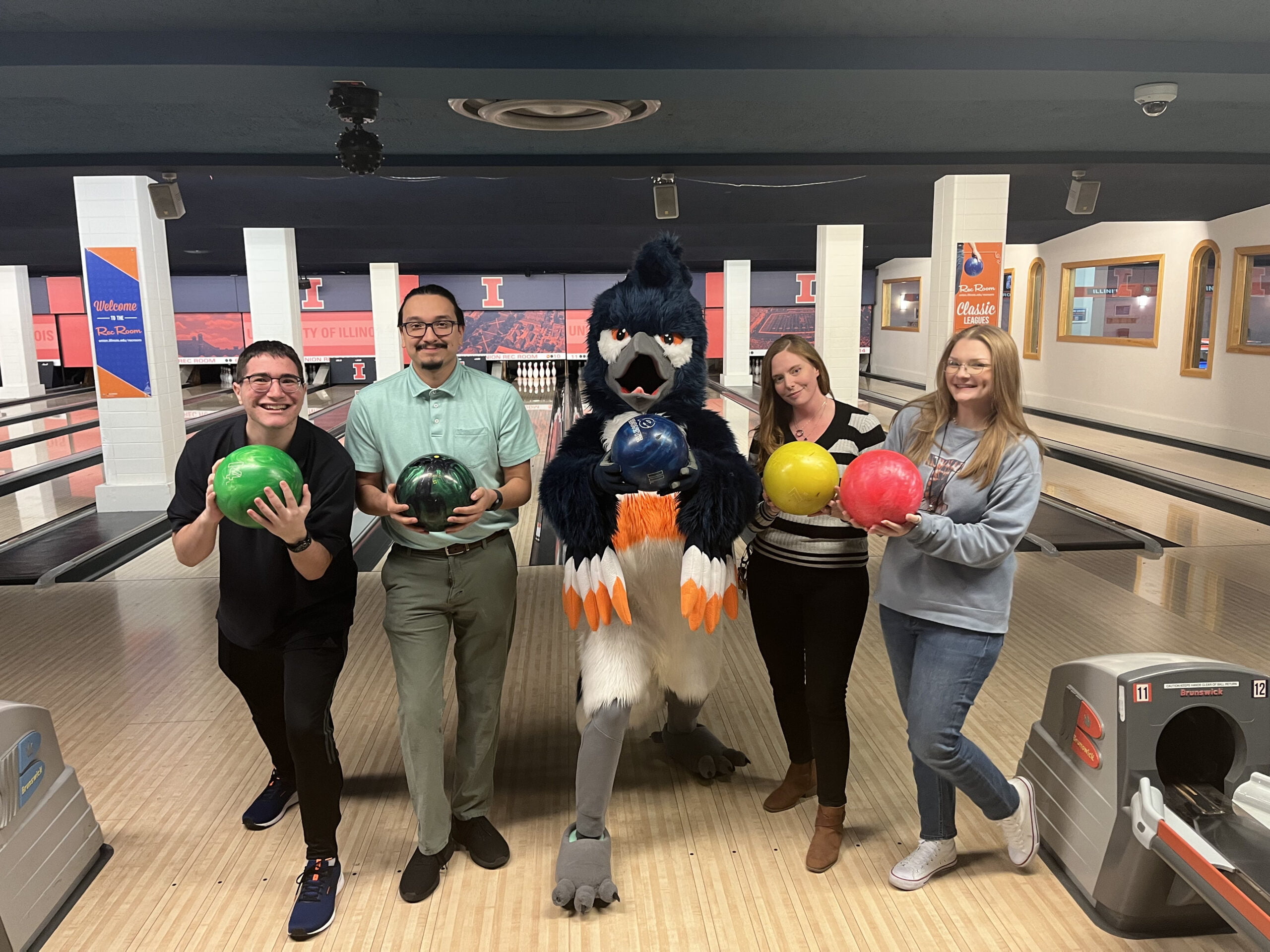 The Belted Kingfisher posing with a group holding bowling balls