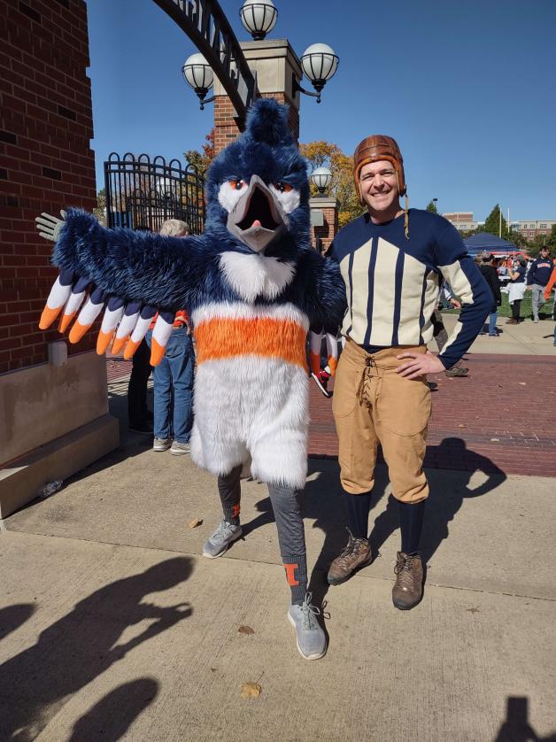 The Kingfisher mascot posing next to a man in traditional American football attire