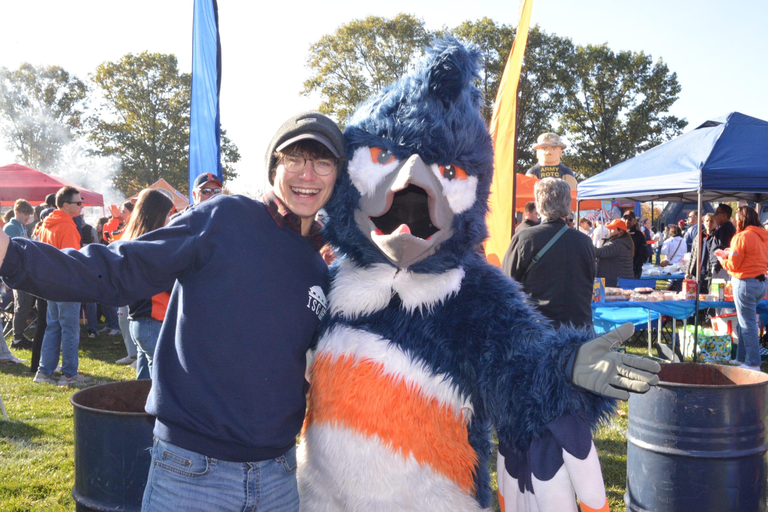 The Belted Kingfisher mascot posing together with an adult wearing a Illinois Student Council sweatshirt