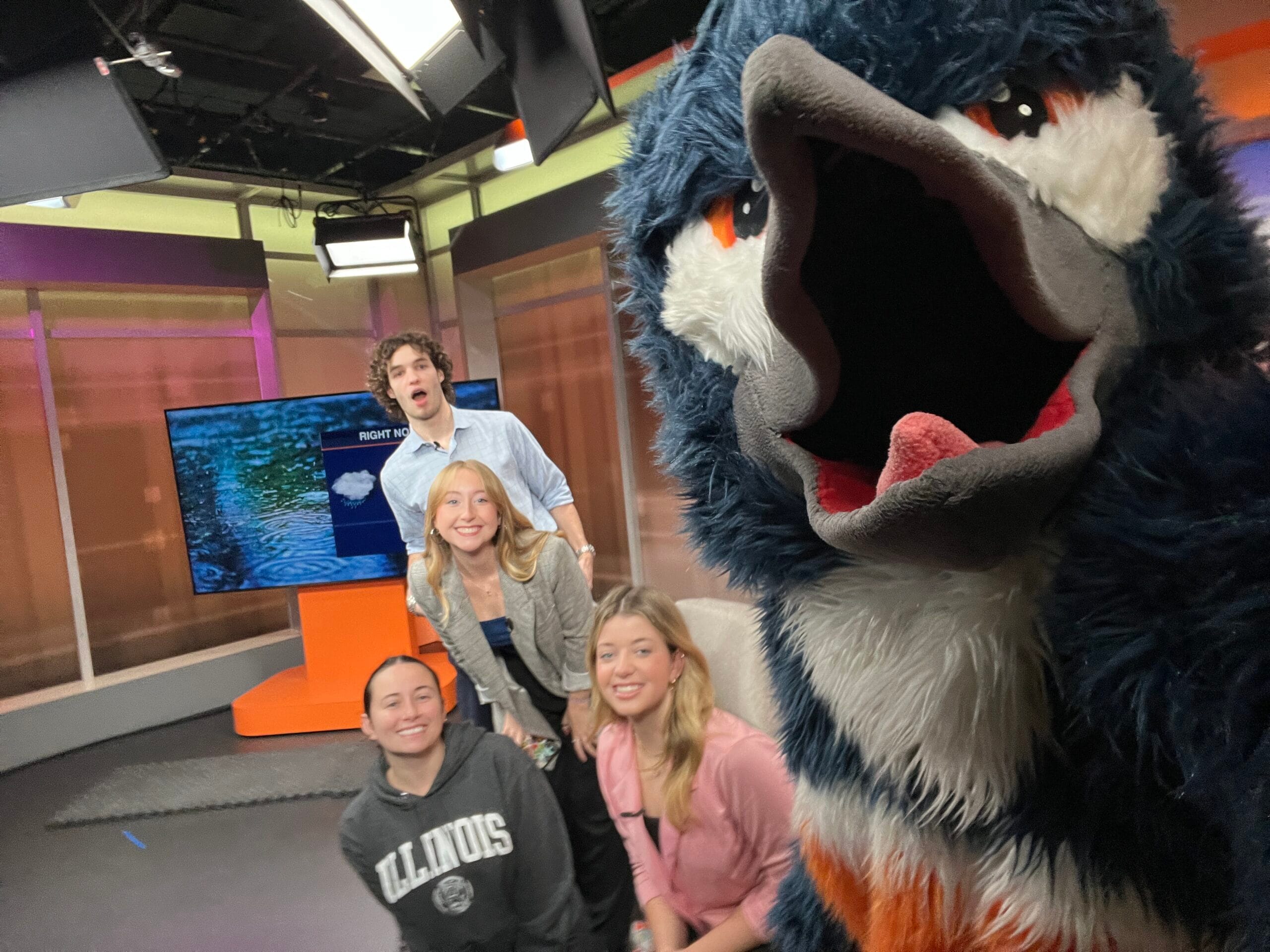 The Belted Kingfisher mascot in a selfie with newscasters from Good Morning Illini