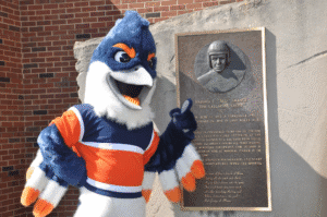 Belted Kingfisher pointing to a plaque about Harold E. "Red" Grange, "The Galloping Ghost"