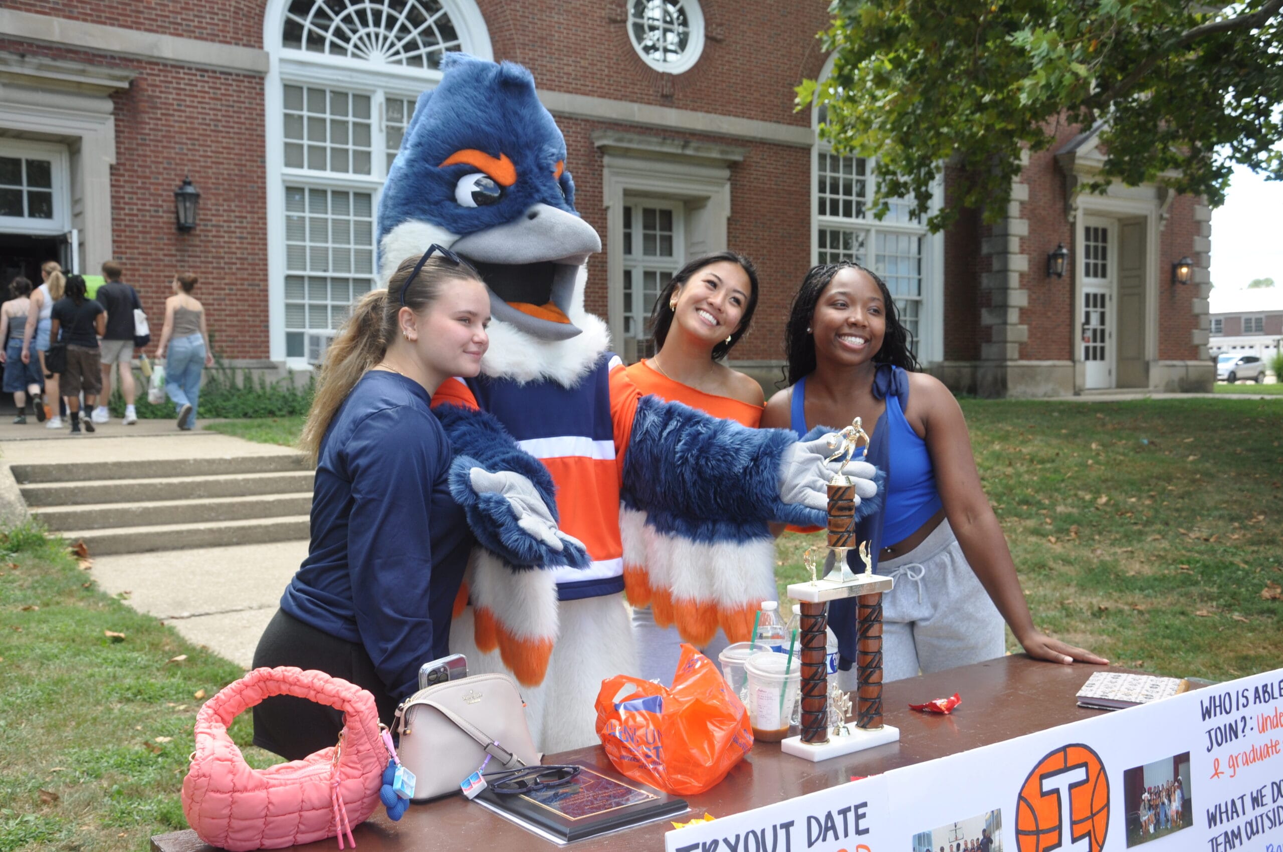 Belted Kingfisher posing together with 3 members of the women's basketball team