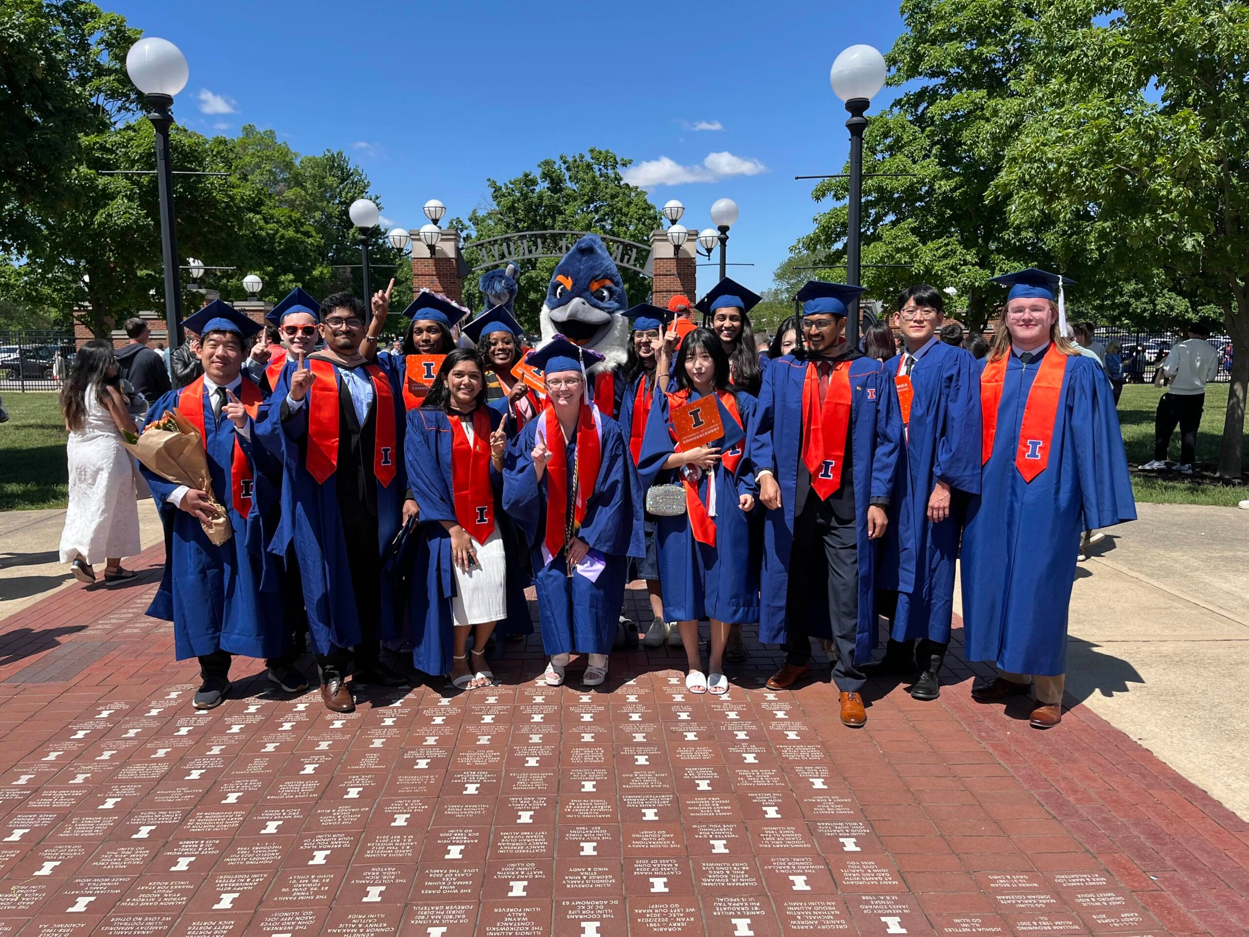Belted Kingfisher posing together with students in graduation regalia