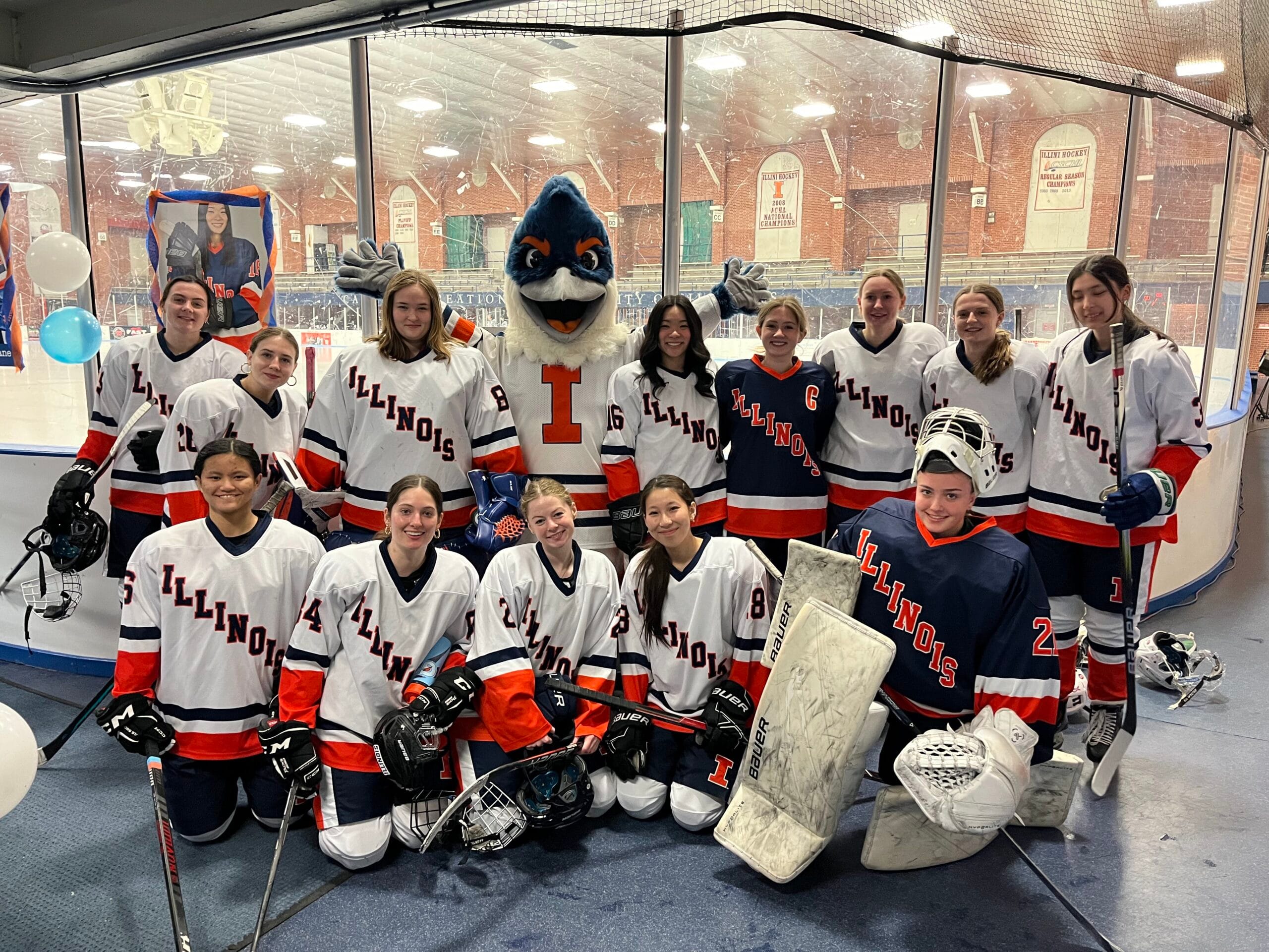 The Belted Kingfisher posing with the University of Illinois women's hockey team